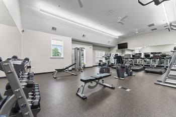 A spacious gym with a variety of equipment including treadmills, weights, and exercise machines.